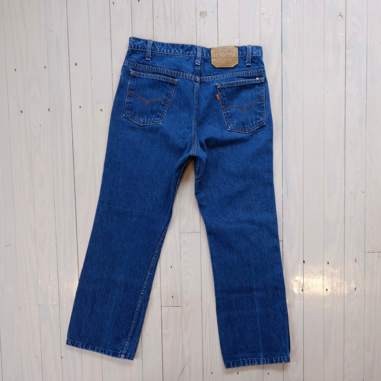 vintage levis orange tab Blue jeans on a light wooden floor
