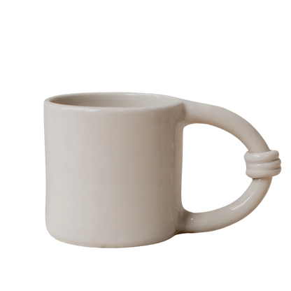 Beige ceramic mug with a unique handle design 