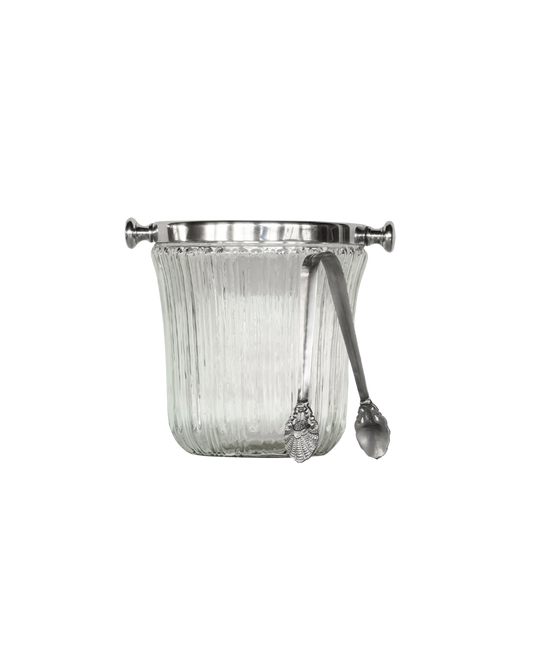 A clear glass ice bucket with antique silver caps on the rim and matching silver ice tongs
