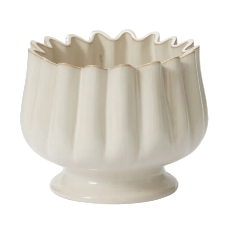 Beige ceramic bowl with wavy rim on a white background