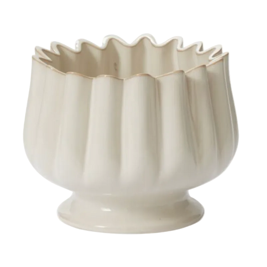 Beige ceramic bowl with wavy rim on a white background