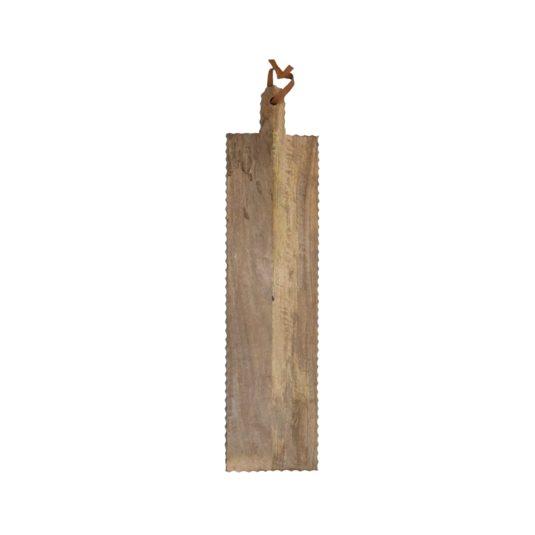 An oversized carved wooden cutting board with a loop for hanging and unique scalloped edges