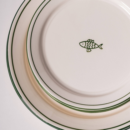 white ceramic dessert plate with green fish and trim detail 