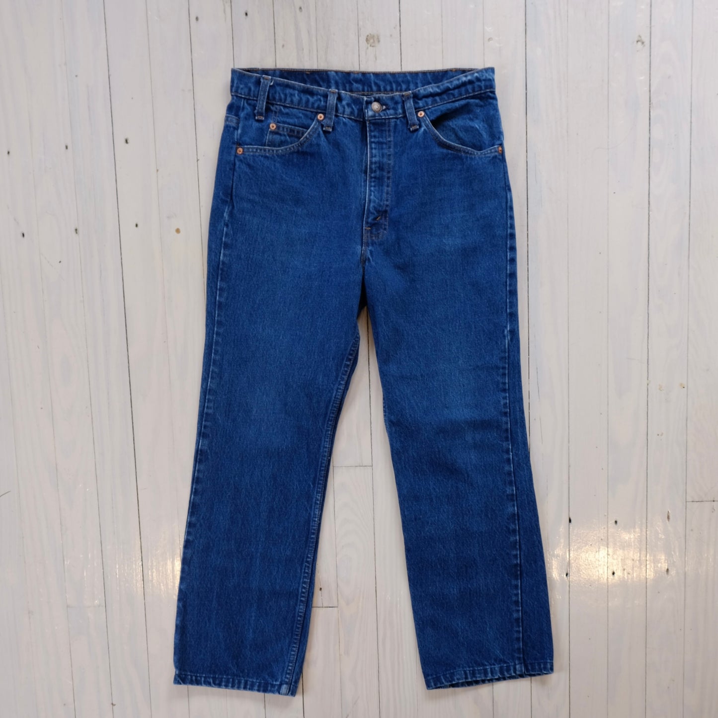 Pair of levis orange tab vintage blue jeans on a light wooden floor