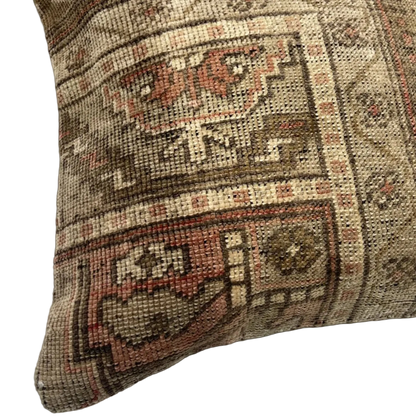 detail view of vintage persian rug bohemian pillow with neutral and muted rose tones